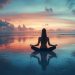 Uma silhueta de uma pessoa sentada de pernas cruzadas em uma pose meditativa em uma praia de areia molhada ao pôr do sol. O céu está vibrante com tons de laranja, rosa e azul, e a água calma cria um reflexo espelhado da cena, aumentando a atmosfera tranquila de paz. | YogaLounge