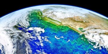 Uma vista da Terra vista do espaço, mostrando águas oceânicas vibrantes em tons de azul, verde e turquesa, nuvens rodopiantes e massas de terra com montanhas cobertas de neve — um planeta belo, porém frágil, frequentemente no centro da ecoansiedade. A escuridão do espaço forma o fundo. | YogaLounge
