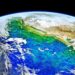 Uma vista da Terra vista do espaço, mostrando águas oceânicas vibrantes em tons de azul, verde e turquesa, nuvens rodopiantes e massas de terra com montanhas cobertas de neve — um planeta belo, porém frágil, frequentemente no centro da ecoansiedade. A escuridão do espaço forma o fundo. | YogaLounge