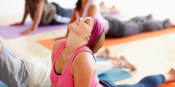 Um grupo de pessoas fazendo yoga. | YogaLounge